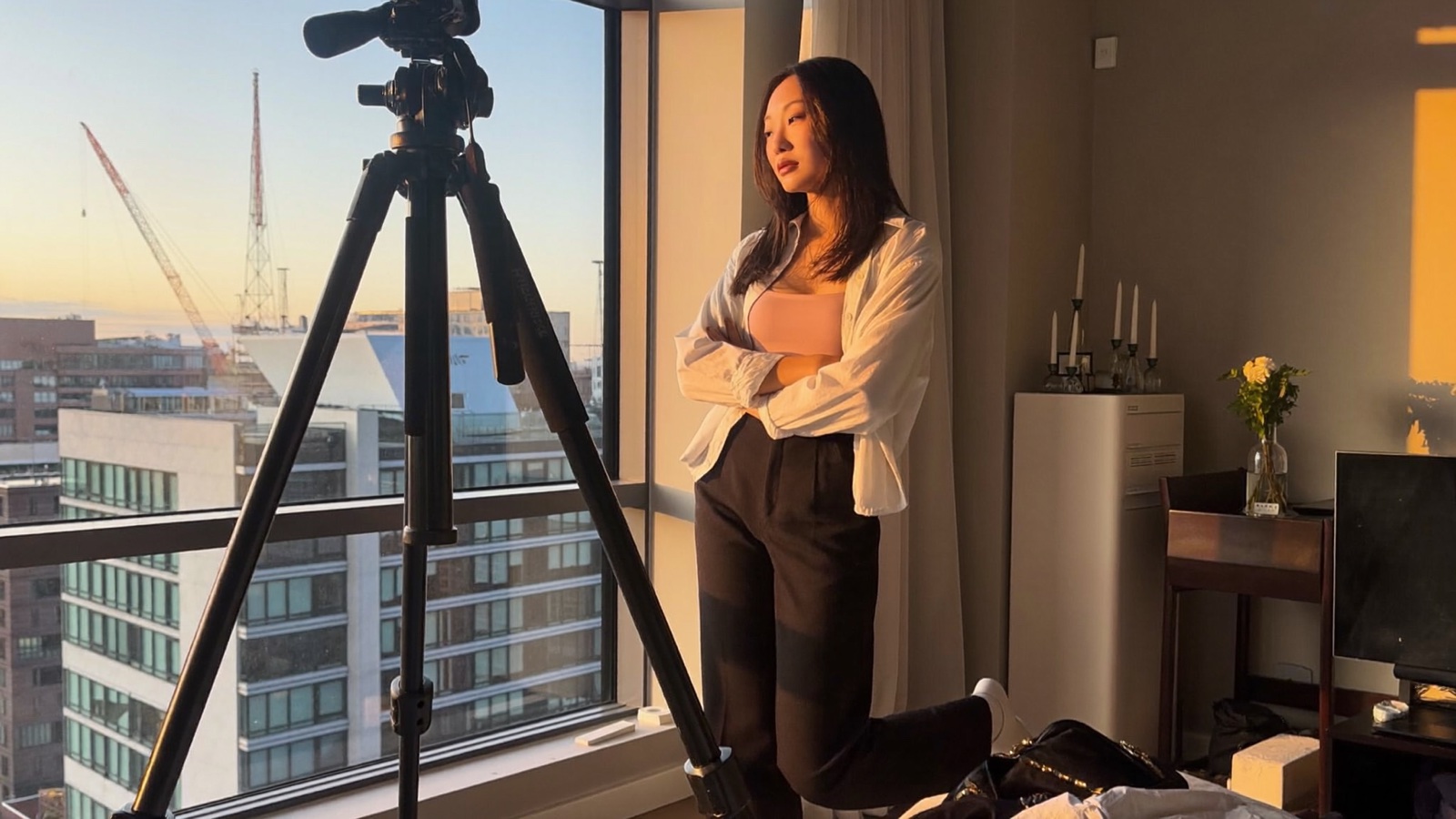 A creator filming beside a window at sunset