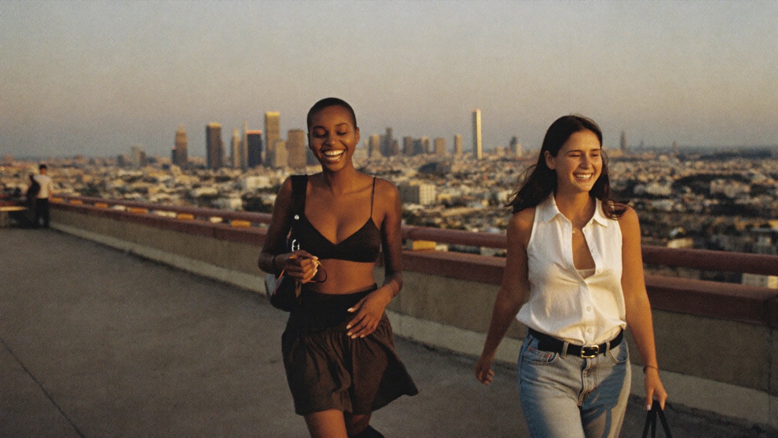 Two creators walking a rooftop terrace at sunset
