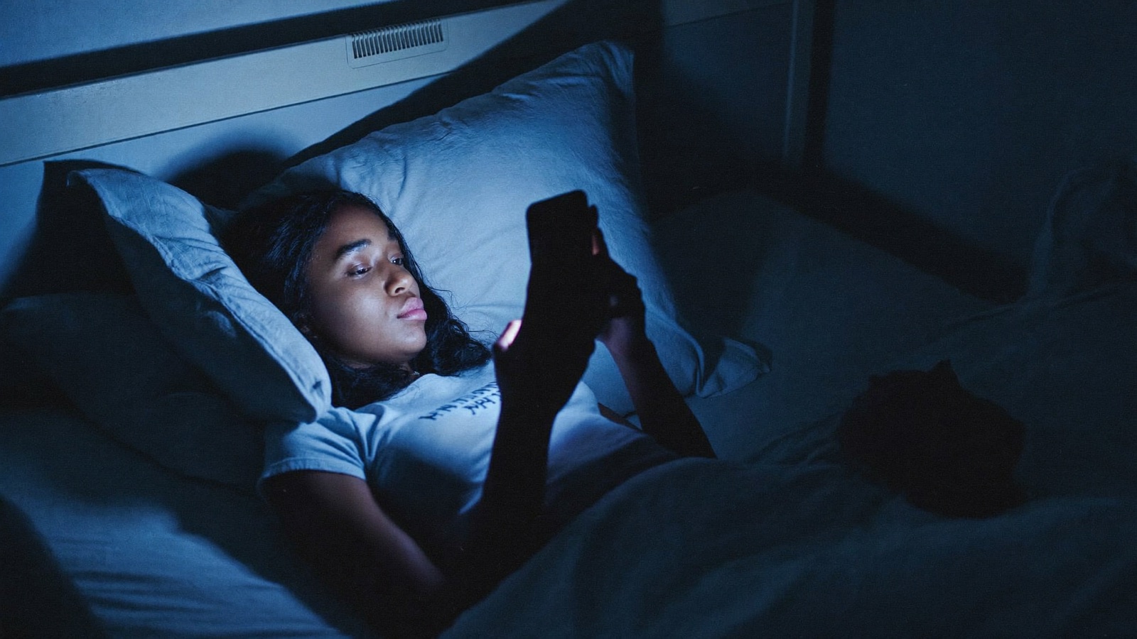 A girl alone in a dark room at night, scrolling her phone, waiting for sales that are not coming