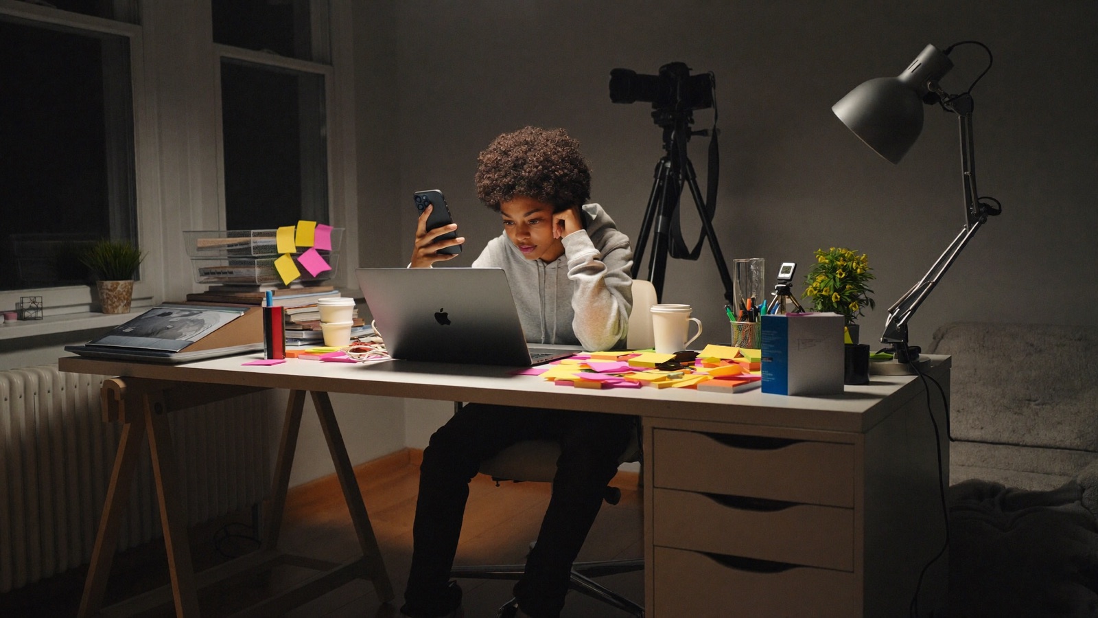 A girl working late and overwhelmed at a cluttered desk, doing every job in her business alone