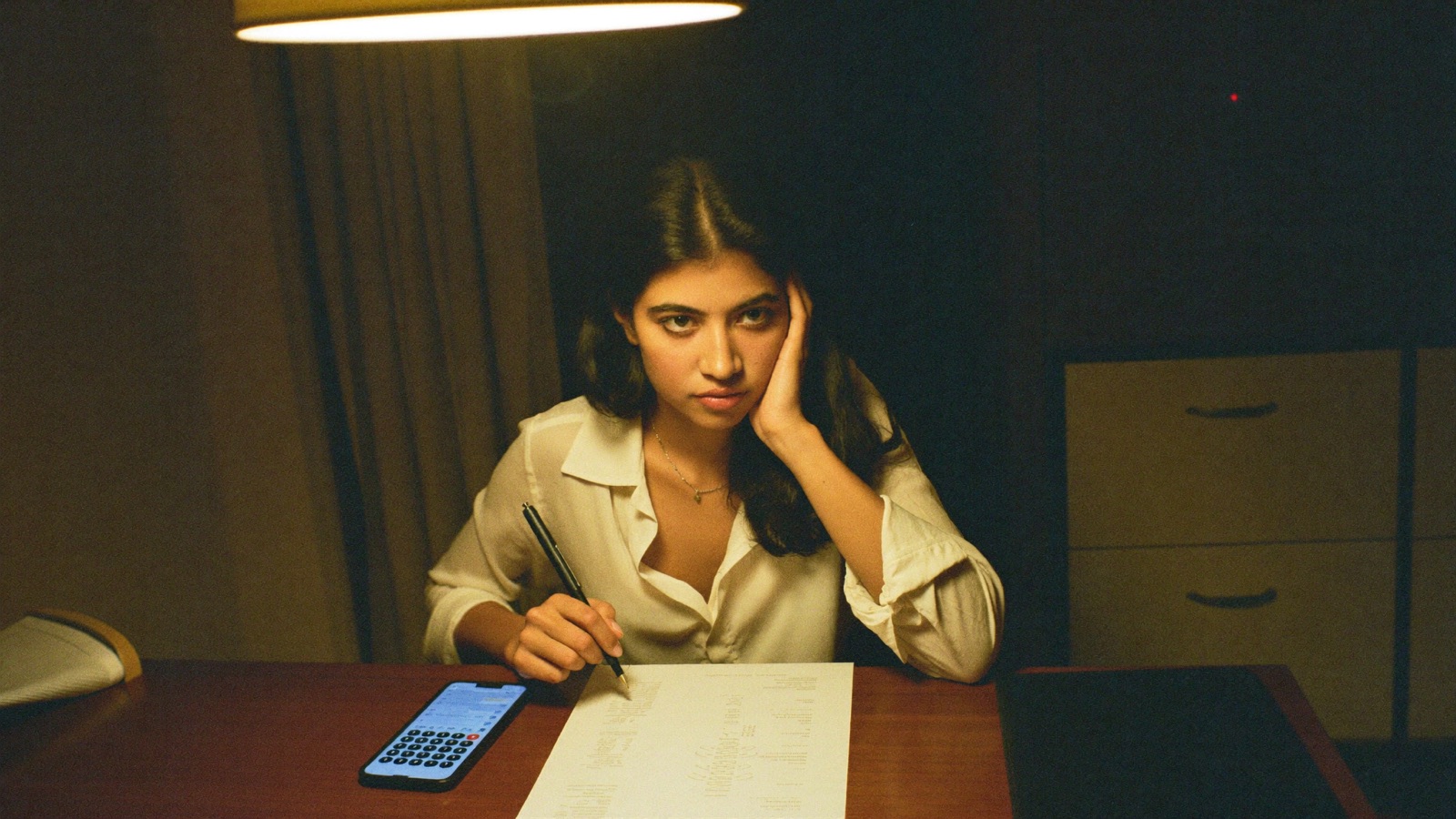 A creator reading a contract carefully at her kitchen table