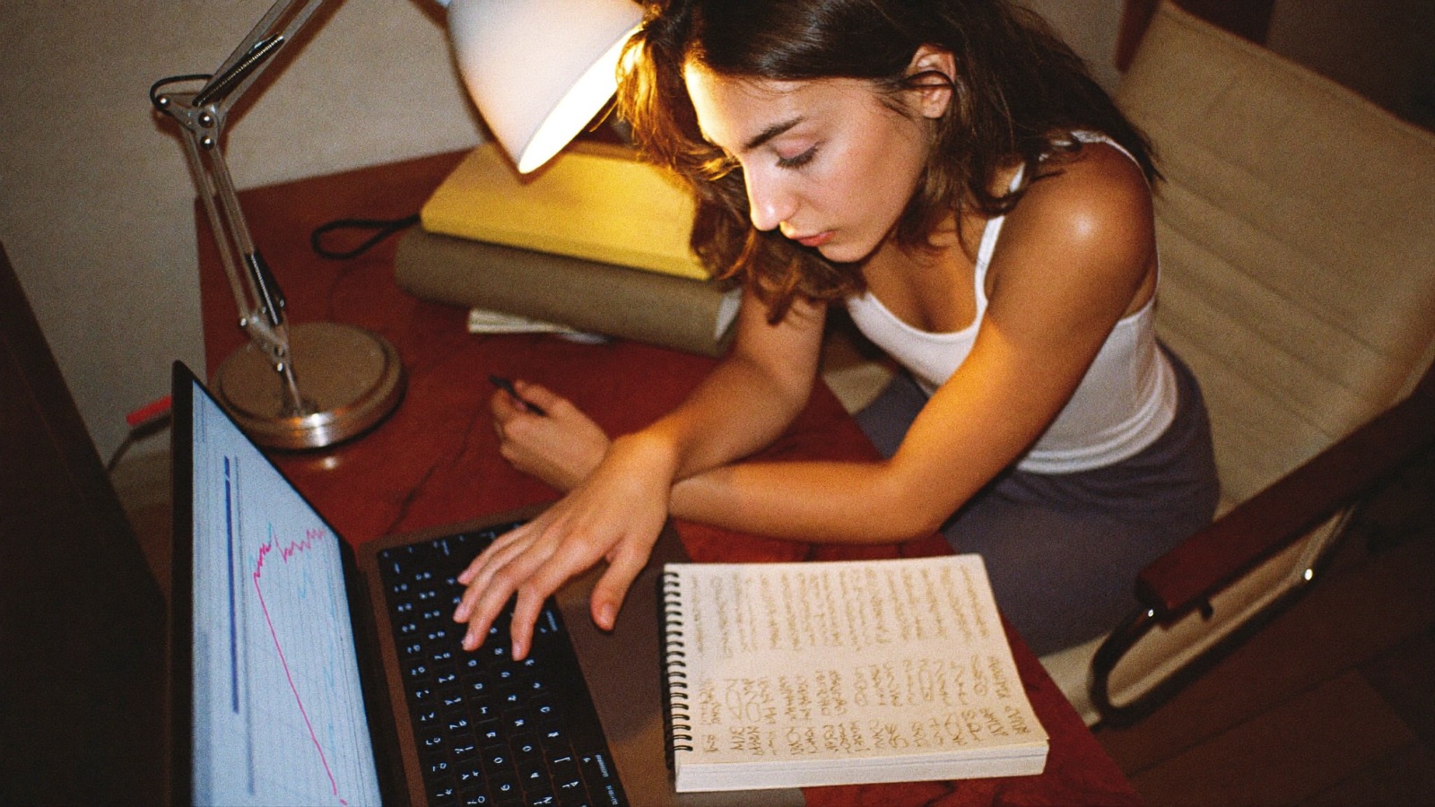 A creator studying her numbers on a laptop at night
