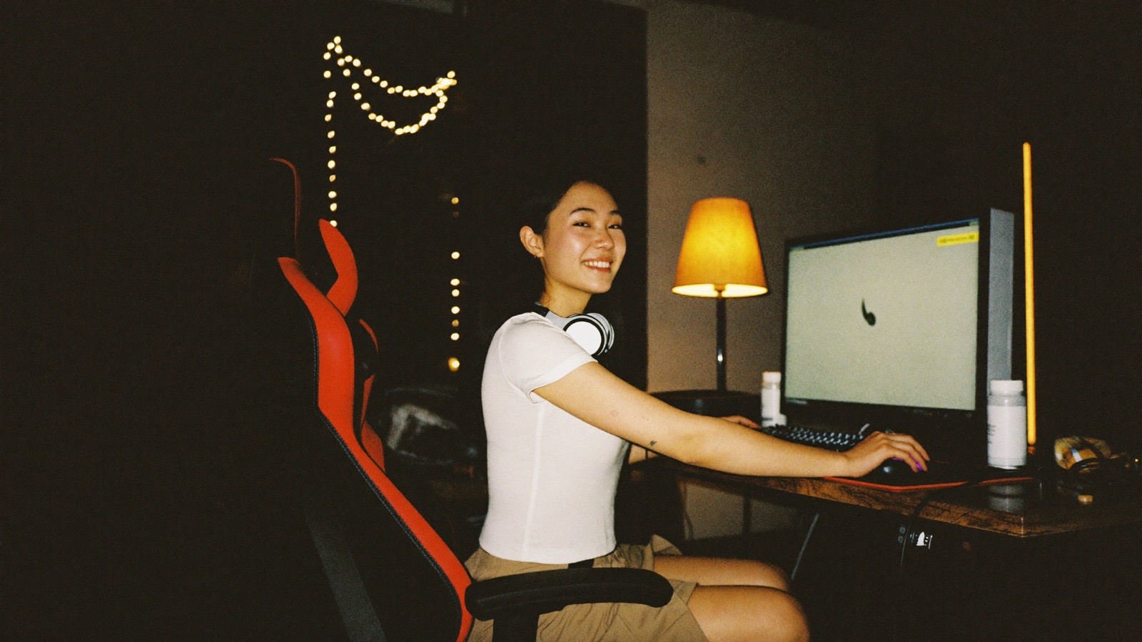 A creator smiling at her monitor at her streaming desk